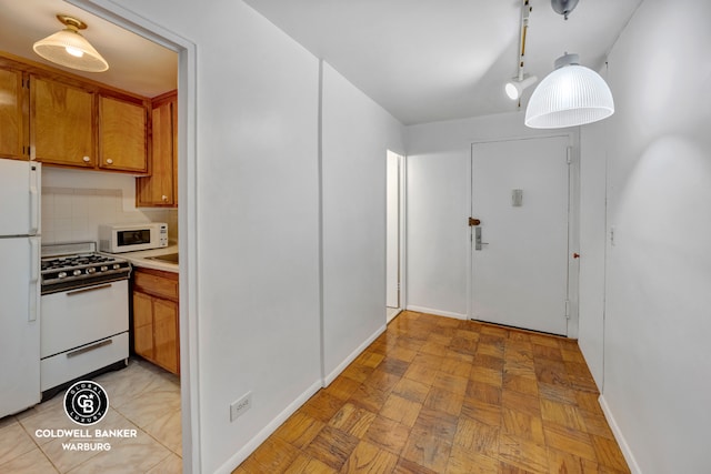 kitchen featuring backsplash and white appliances