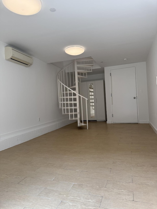 362 W 127th St Unit 1-A, New York City, NY 10027 - spare room featuring a wall unit AC, stairs, and baseboards