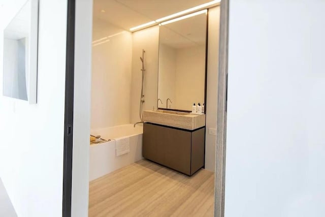 bathroom featuring hardwood / wood-style flooring, sink, and shower / bathtub combination