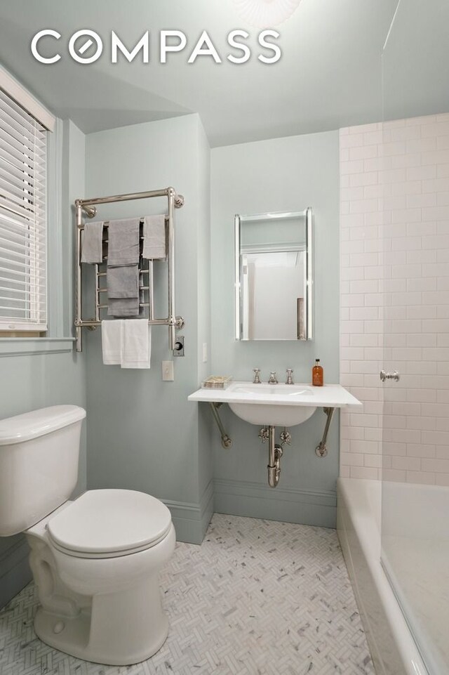 full bathroom with toilet, baseboards, and shower / washtub combination