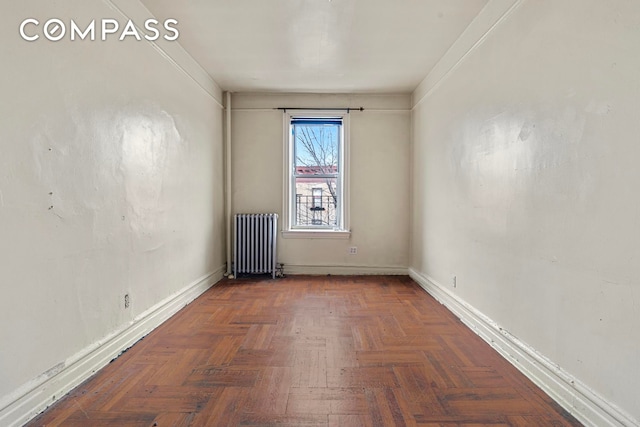 empty room with radiator and baseboards