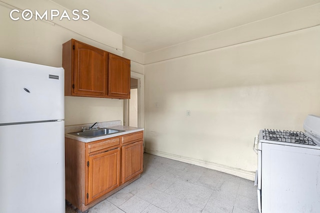 88 Brooklyn Ave Unit D5, New York City, NY 11216 - kitchen featuring white appliances, light countertops, light floors, and brown cabinetry