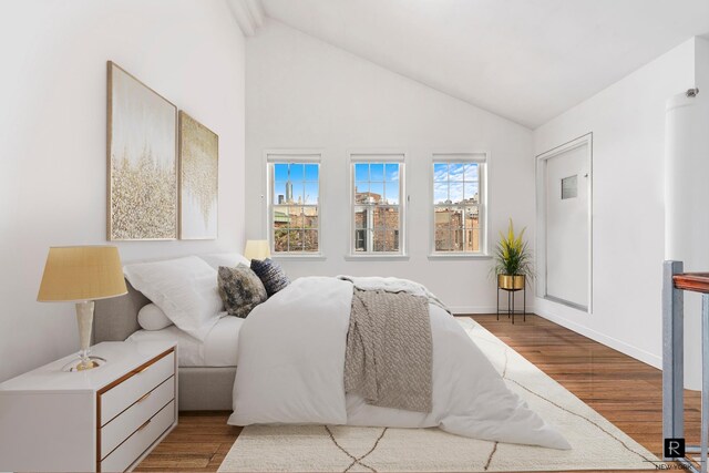 bedroom with light hardwood / wood-style floors and lofted ceiling