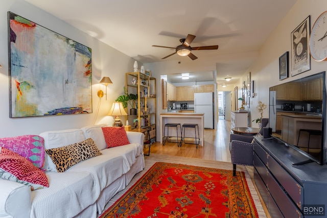 living room featuring light wood-style flooring and a ceiling fan