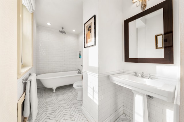 bathroom with sink, a washtub, and toilet