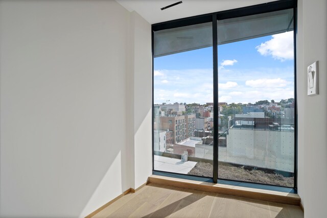 179 20th St Unit 8B, New York City, NY 11232 - unfurnished room featuring floor to ceiling windows and wood finished floors