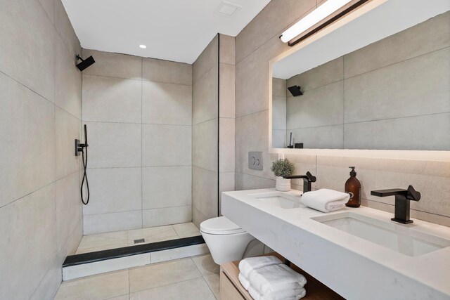 179 20th St Unit 8B, New York City, NY 11232 - bathroom with tile walls, visible vents, toilet, tiled shower, and a sink