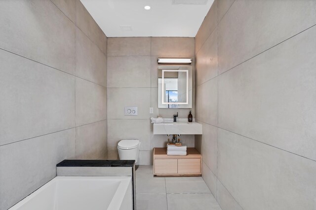 179 20th St Unit 8B, New York City, NY 11232 - bathroom with tile walls, a bathing tub, tile patterned floors, and a sink