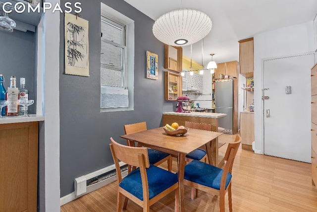 dining space featuring light hardwood / wood-style floors and a baseboard radiator