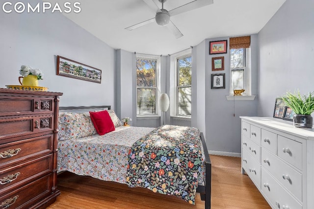 bedroom with light wood-type flooring, ceiling fan, and multiple windows