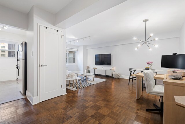 office featuring an inviting chandelier, dark parquet floors, and rail lighting