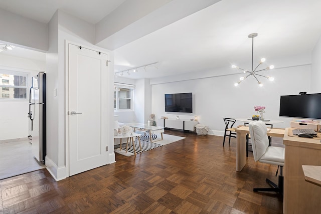 home office featuring a notable chandelier, track lighting, and baseboards