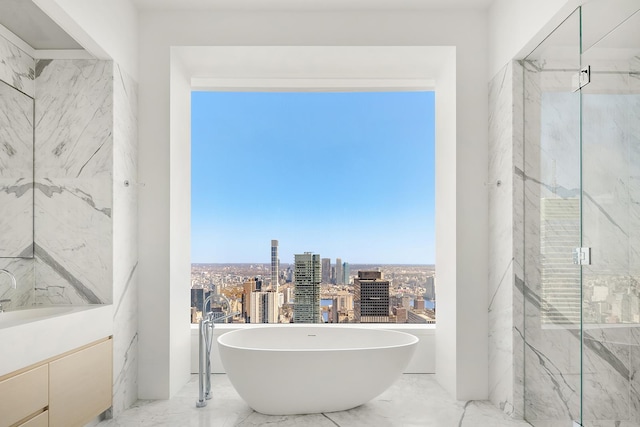 bathroom featuring a marble finish shower, marble finish flooring, a soaking tub, and a city view