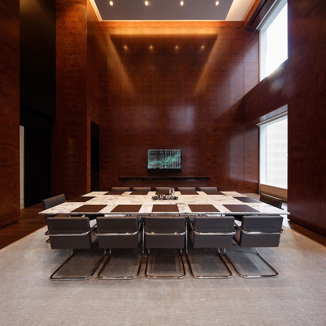 common area featuring a towering ceiling and wooden walls