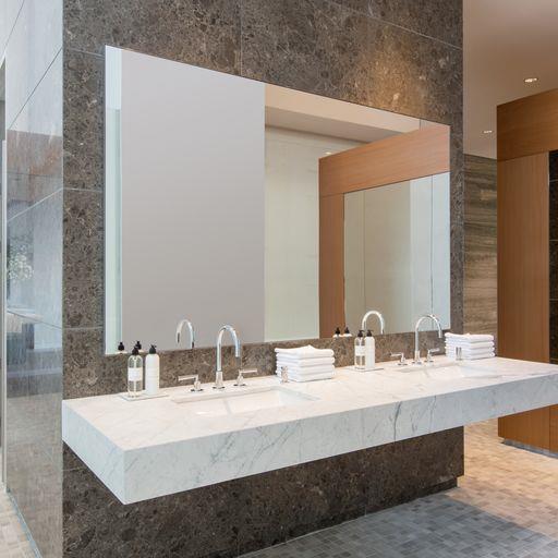 full bath with double vanity and tile walls