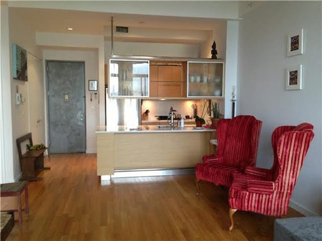 85 Adams St Unit 15-B, New York City, NY 11201 - kitchen featuring light wood-type flooring, glass insert cabinets, a peninsula, light countertops, and baseboards