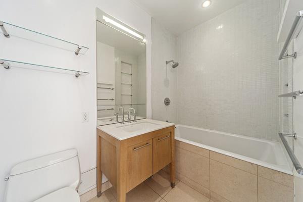 85 Adams St Unit 15-B, New York City, NY 11201 - bathroom featuring toilet, vanity, tiled shower / bath, and tile patterned flooring