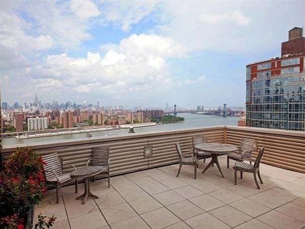 view of patio featuring a water view and a balcony