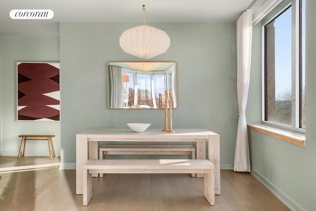 dining area featuring visible vents, baseboards, and wood finished floors