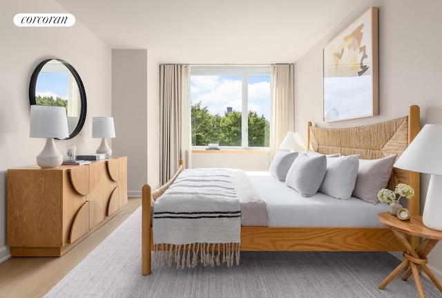 bedroom featuring light wood-style flooring, visible vents, and baseboards