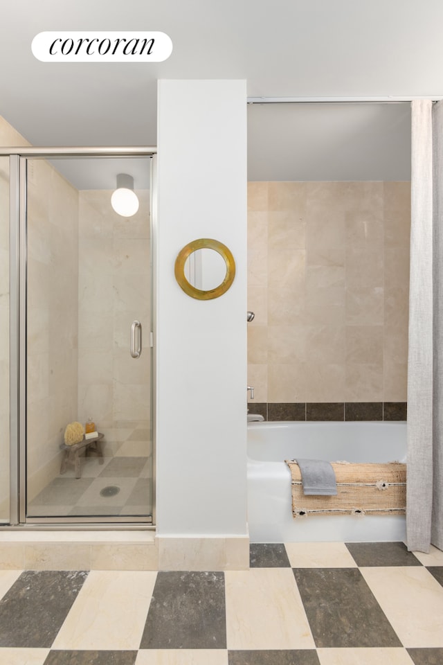 bathroom featuring a bathtub and a stall shower