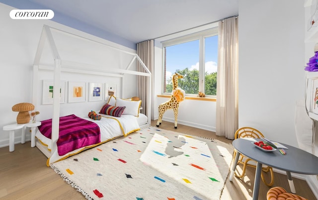 bedroom with visible vents, baseboards, and wood finished floors