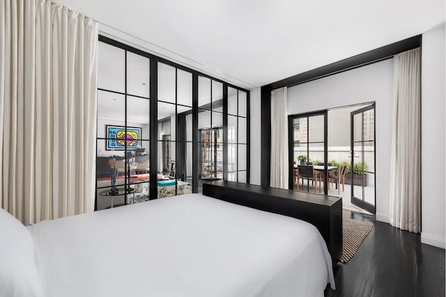 bedroom with dark wood-type flooring and expansive windows