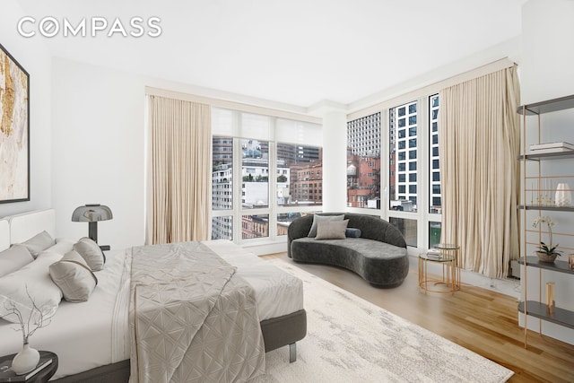 bedroom featuring expansive windows and wood finished floors