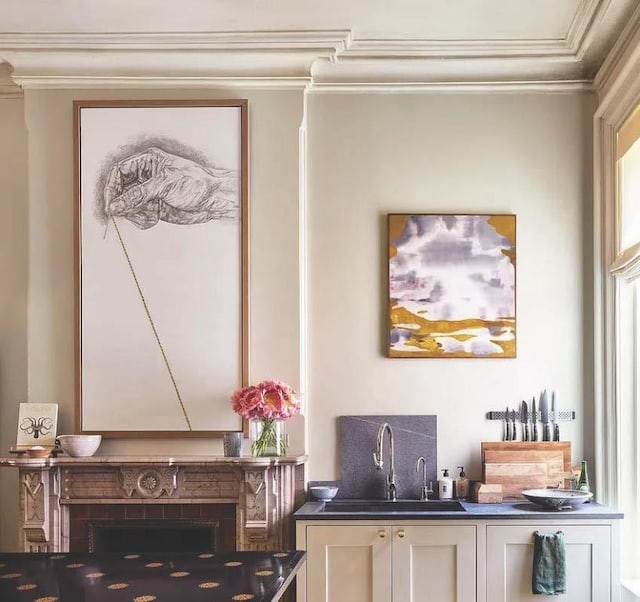 interior space featuring sink, white cabinetry, and crown molding