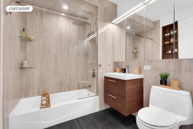 full bathroom featuring vanity, bathtub / shower combination, tile walls, and toilet