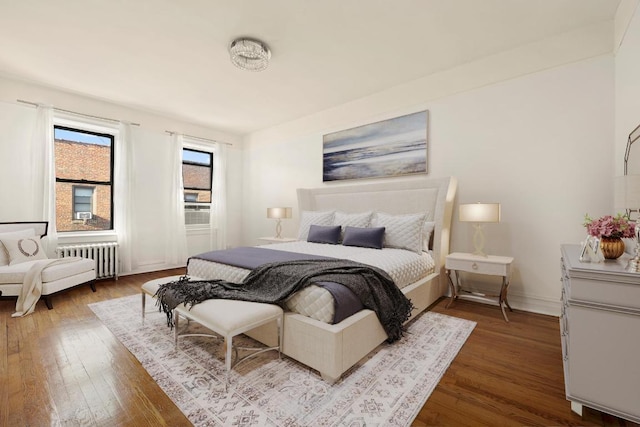 bedroom with radiator, baseboards, and wood finished floors