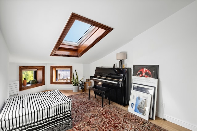 bedroom with wood-type flooring and lofted ceiling with skylight