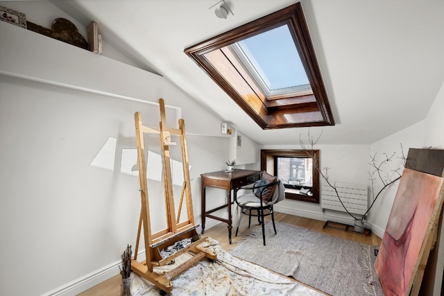 bonus room with wood-type flooring and lofted ceiling with skylight