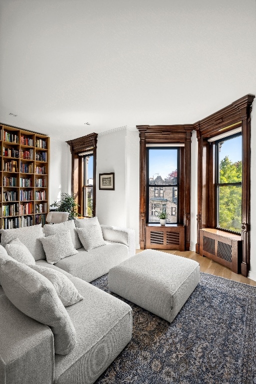 living room featuring hardwood / wood-style floors, a healthy amount of sunlight, and radiator heating unit