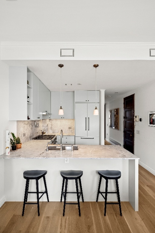 kitchen featuring white cabinetry, kitchen peninsula, and a kitchen bar