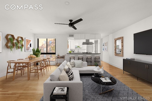 living room with ceiling fan and light hardwood / wood-style flooring