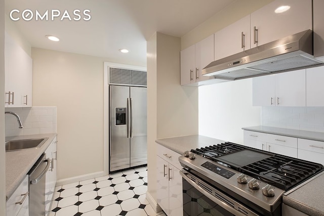 kitchen featuring stainless steel appliances, a sink, white cabinetry, and under cabinet range hood