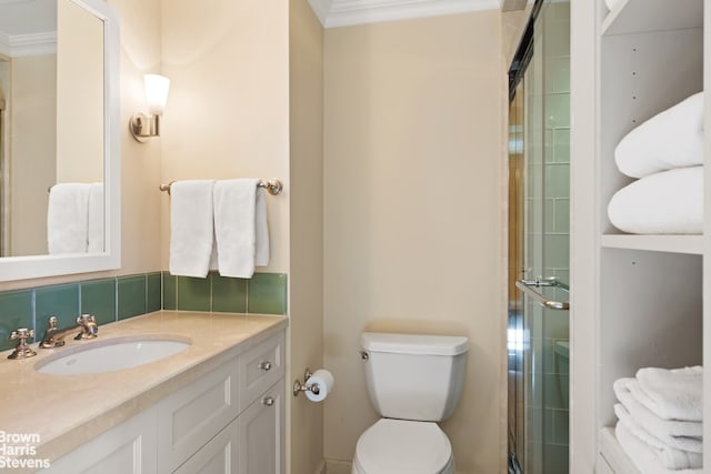 bathroom with ornamental molding, toilet, an enclosed shower, and vanity