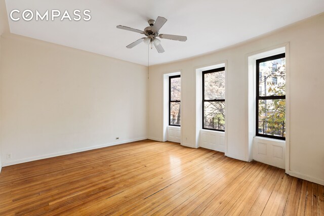 unfurnished room featuring a wealth of natural light, ceiling fan, and light wood-type flooring