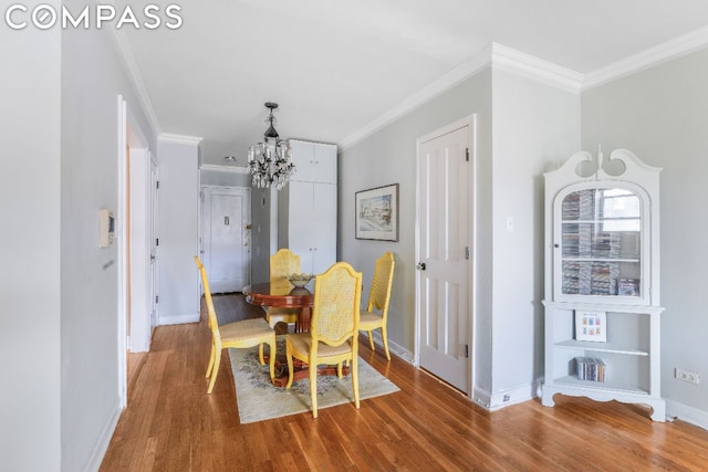 dining area featuring wood-type flooring, a chandelier, and crown molding