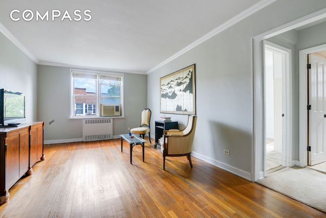 living area featuring radiator heating unit, ornamental molding, and light wood-style flooring