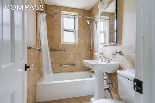 bathroom featuring toilet, tile patterned flooring, tile walls, and shower / tub combo with curtain