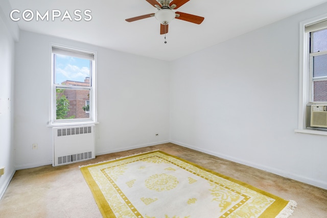 unfurnished room featuring carpet, radiator, a healthy amount of sunlight, and baseboards