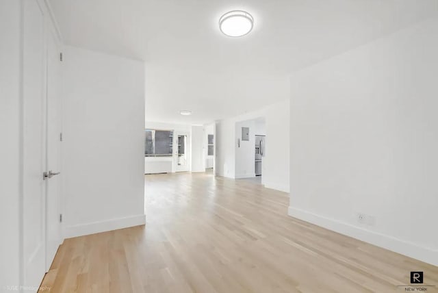 empty room featuring light wood-type flooring and baseboards