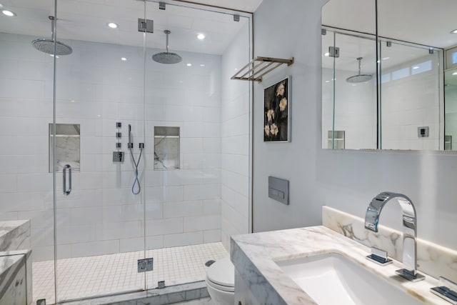 bathroom featuring vanity, an enclosed shower, and toilet