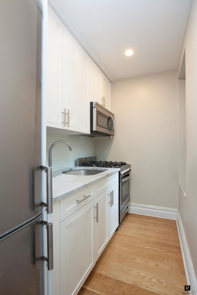 156-08 Riverside Dr W Unit 1-A, New York City, NY 10032 - kitchen featuring appliances with stainless steel finishes, baseboards, white cabinets, light wood-type flooring, and recessed lighting