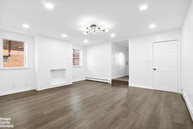 spare room with a baseboard heating unit and dark hardwood / wood-style floors