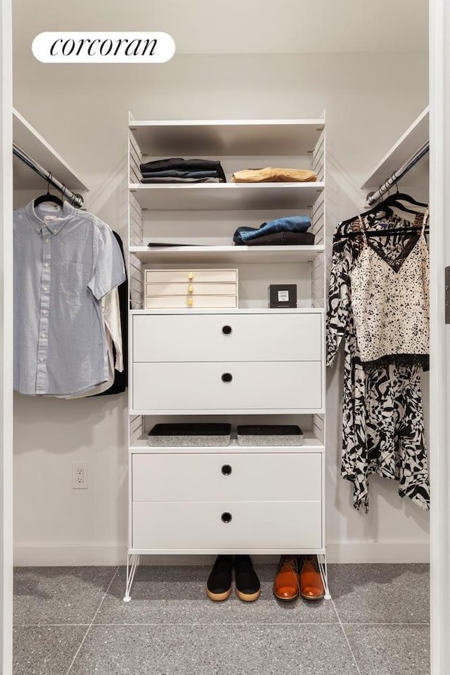 spacious closet featuring granite finish floor