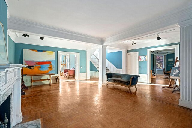 game room with parquet floors, a fireplace, ornamental molding, and ornate columns