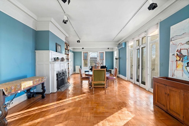 dining room featuring an AC wall unit, radiator heating unit, rail lighting, light parquet floors, and ornamental molding